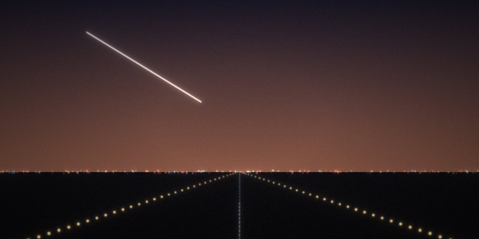 Runway lights at dusk with an aircraft on approach